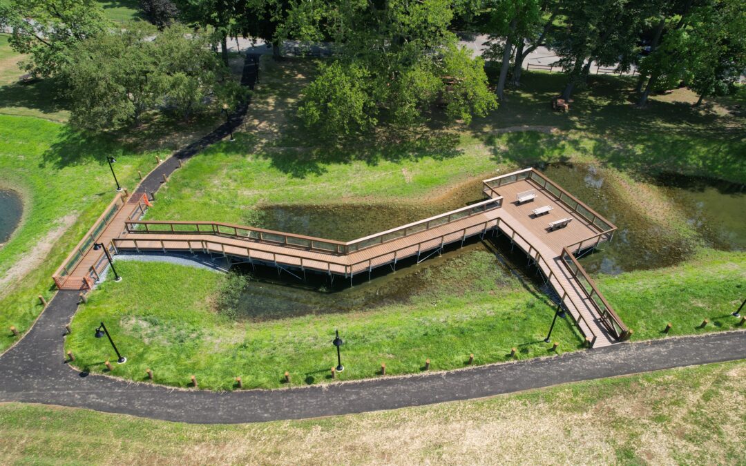 custom build walking bridge sitting on top of wetland property with a walking path in front of it